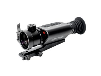 Close-up of a black rifle scope with control buttons and mounting rail on a white background.
