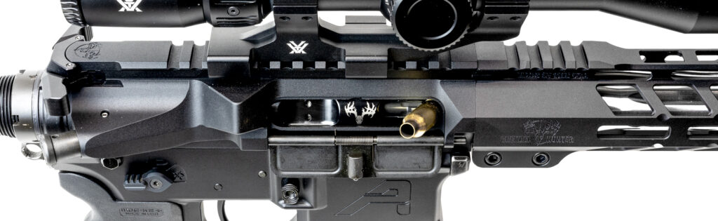 Side profile of a Grendel Hunter 6mm ARC rifle on an Aero lower showing a stovepipe malfunction, with a spent brass casing crushed and trapped horizontally inside the ejection port.