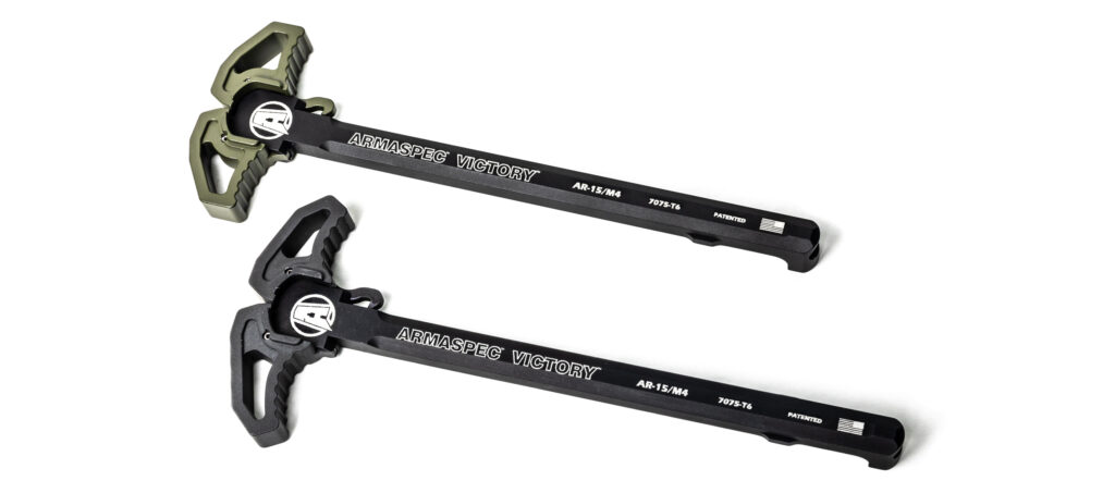 Product photo showcasing a pair of Armaspec Victory ambidextrous charging handles for AR-15 and M4 platforms on a white background. The upper unit features an olive drab green (ODG) curved handle with serrated wings, while the lower unit is finished in standard anodized black, both clearly displaying the white Armaspec laser engravings on the shaft.